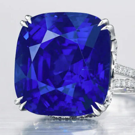 Ring with a large blue gemstone and smaller diamonds on a light gray background